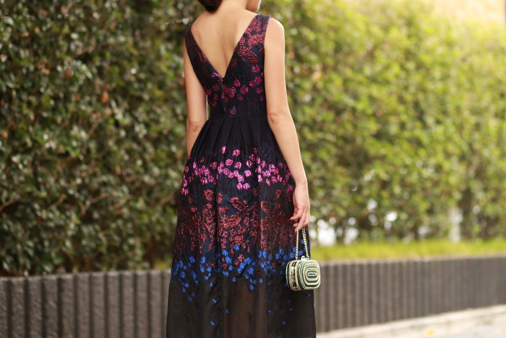 ネイビーのＡラインドレスにパープル、ブルーで全体にお花の刺繍が施されている膝下丈の華やかなドレス