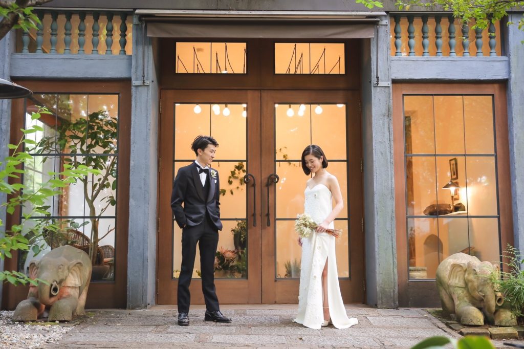 デルポソの白いベアトップで刺繍が施されたウェディングドレスを着ている花嫁と新郎。