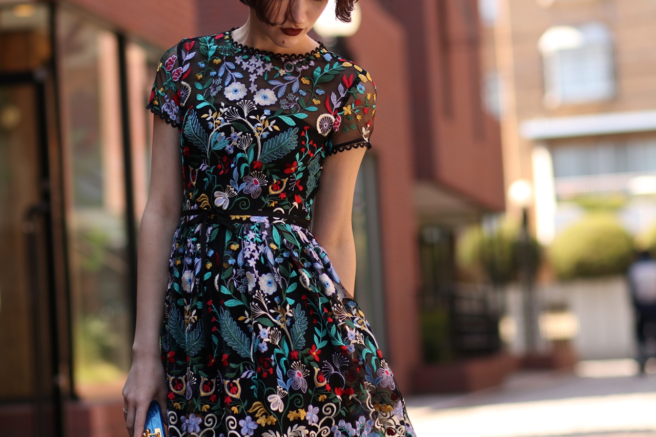 ML Monique Lhillier 黒地にカラフル刺繍が施されている半袖のロングドレス。