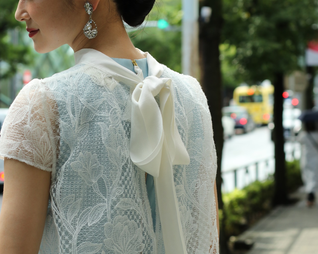 骨格ナチュラルの方におすすめのレンタルドレスはKhon Hooi(クーン・フーイ)の背中にリボンが付いた白いレースのガウンに水色のインナードレスが透けたレンタルドレス